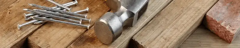 Hammer and nails on hardwood flooring boards in Dallas, TX