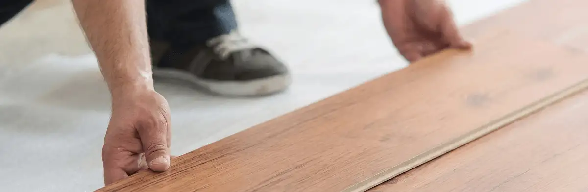 A professional installing laminate flooring in Dallas, TX